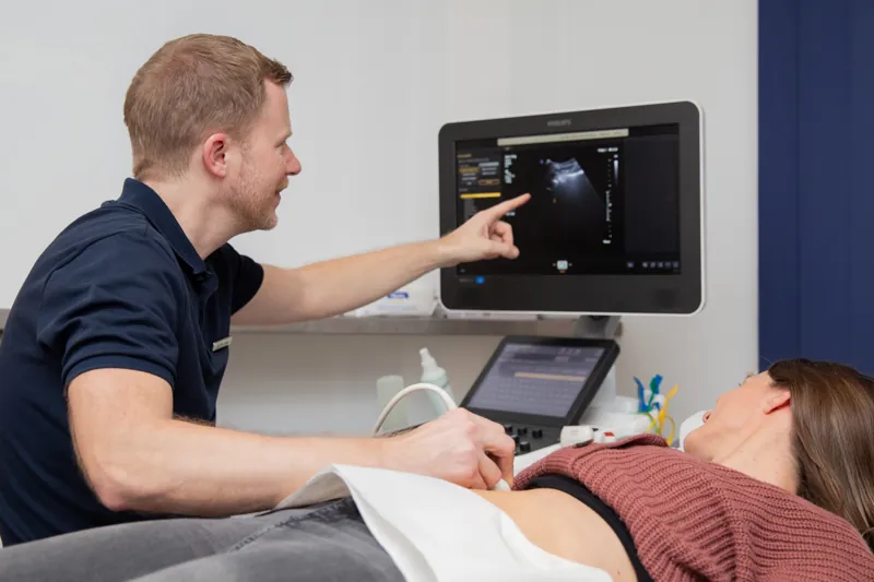 Arzt erklärt einer Patientin das Ultraschallbild